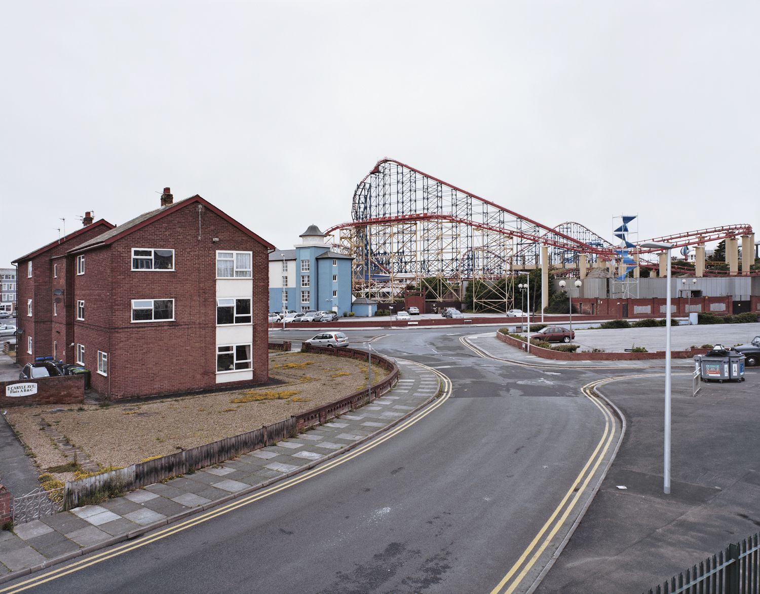 Péter Ildikó: A Blackpool Pleasure Beach és a Big Blue Hotel a Carlyle Avenue-n és a Burlington Road-on, West Blackpool, Anglia. Észak-Anglia: Az ipari forradalom útja, 2012, 4x5”-es színes negatív nyersanyag, 130x105 cm-es archív inkjet nyomatIldikó Péter: Blackpool Pleasure Beach and the Big Blue Hotel on Carlyle Avenue andBurlington Road, West Blackpool, England. Northern England: The Industrial Revolution Route, 2012, 4x5” colour negative film enlarged as 130 x 105 cm, archive inkjet Péter Ildikó