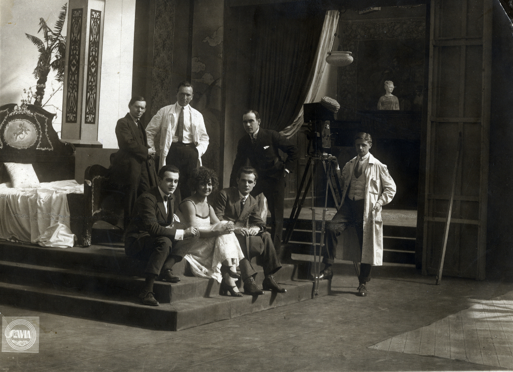 Kép Kertész Mihály (Michael Curtiz) fotóalbumából. A negyven fotót tartalmazó albumot 2019-ben a rendező unokahúga, a Kaliforniában élő Linda Goldfarb ajándékozta a Filmarchívumnak. A felvétel valószínűleg Bécsben készült 1919–1920 körül. Állnak: Siklósi Iván, Kertész Mihály, Fodor Oszkár, a kamera mellett: Vass Károly, ülnek: Petrovics Szvetiszláv, Kovács Ilonka/Lucy Doraine, Várkonyi Mihály ©NFI |  Picture from the photo album of Mihály Kertész (Michael Curtiz). The album, which contains forty photos, was