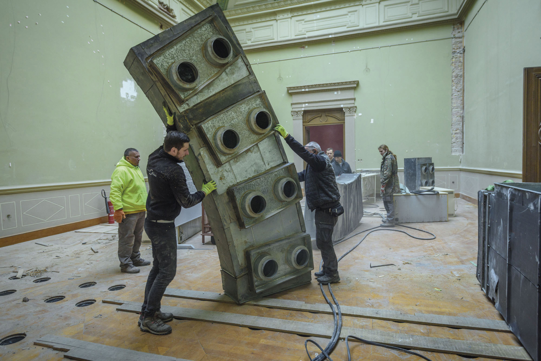 A szellőzőrendszer elemeinek eltávolítása a Magyar Tudományos Akadémia épületéből a „Trapped Breath” című installációhoz. A művész jóvoltából / Removing the elements of the ventilation system from the building of the Hungarian Academy of Sciences for the installation entitled Trapped Breath. Courtesy of the Artist